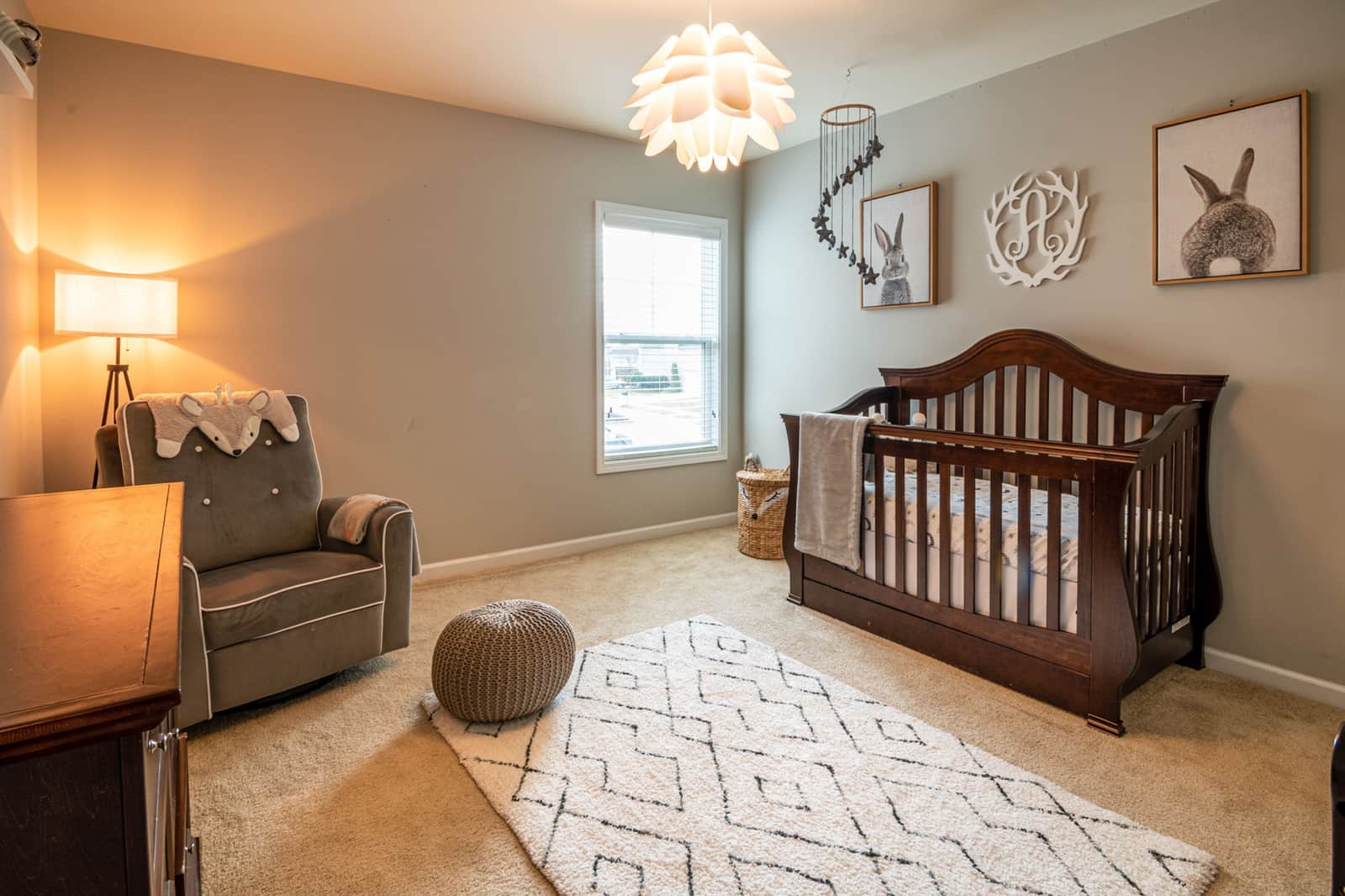 A nursery with a crib beside a window covered against daylight