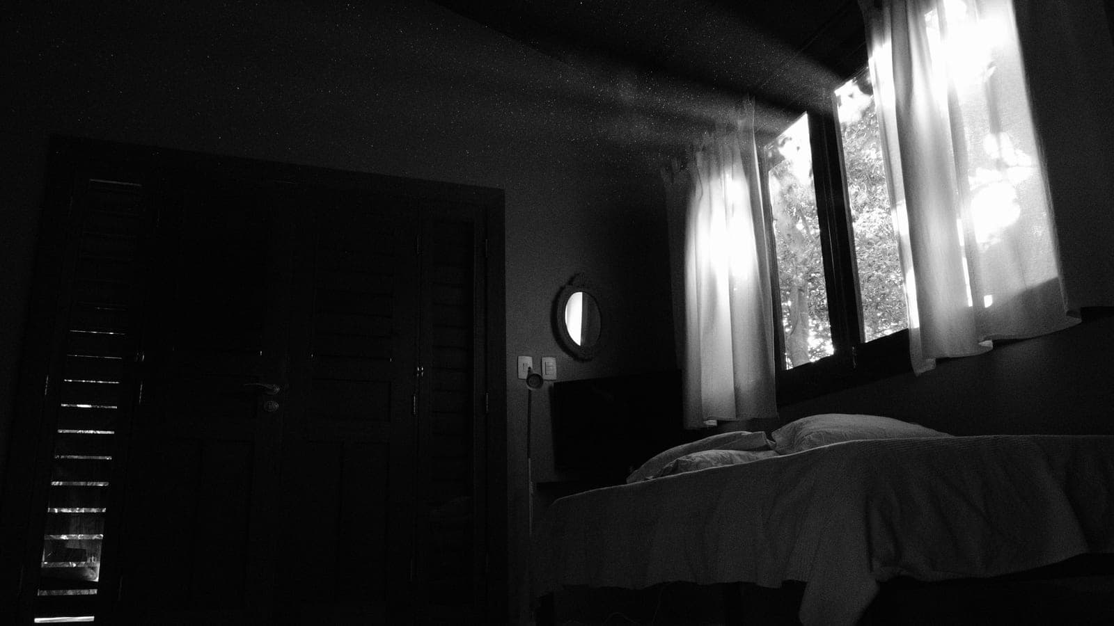 A bedroom with heavy blackout curtains drawn across the window
