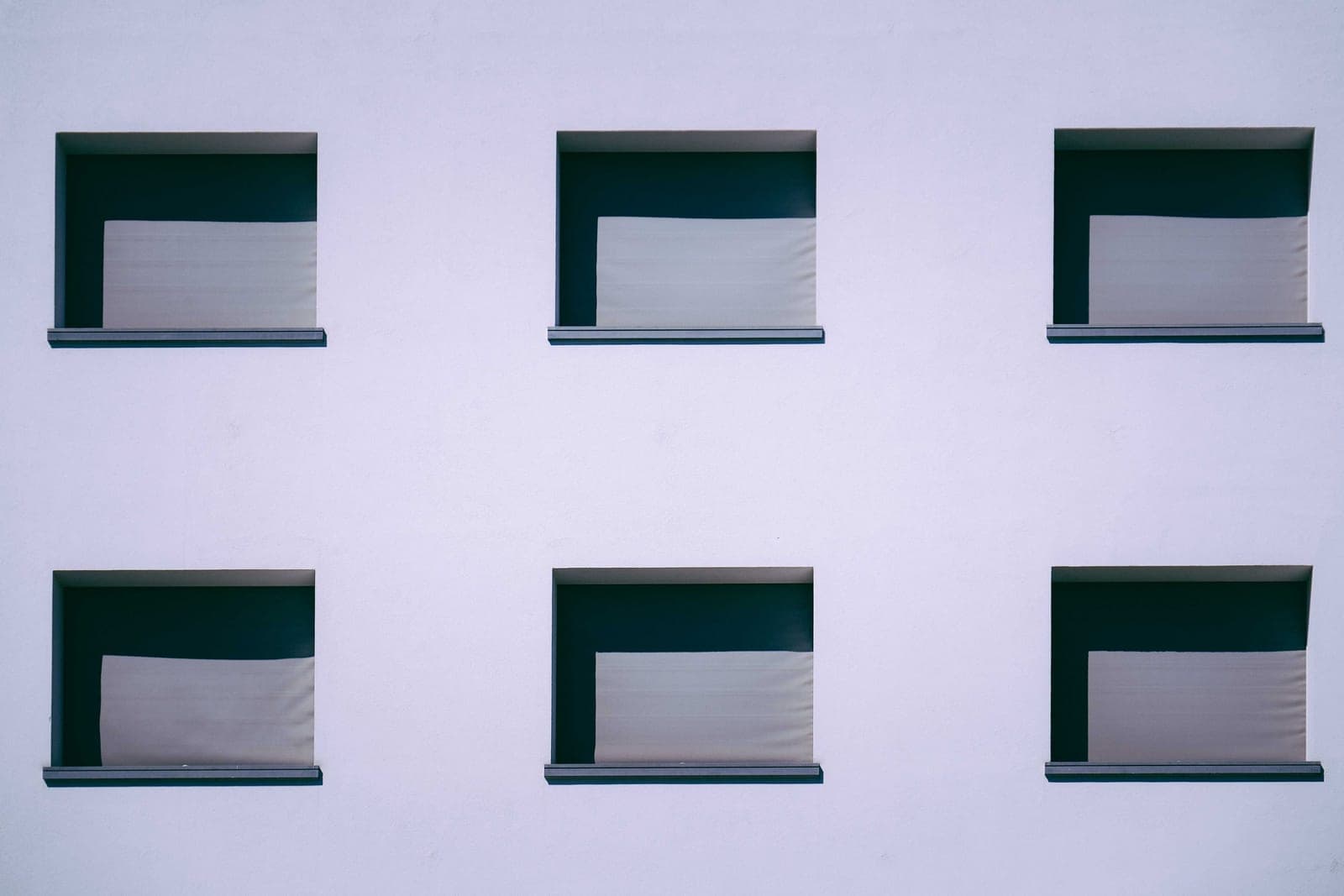 A neutral cellular shade covering a modern window
