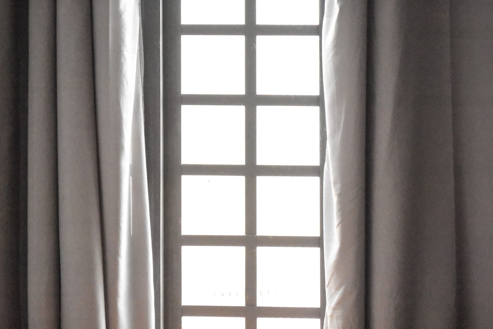 A roman shade with folded fabric covering part of a window