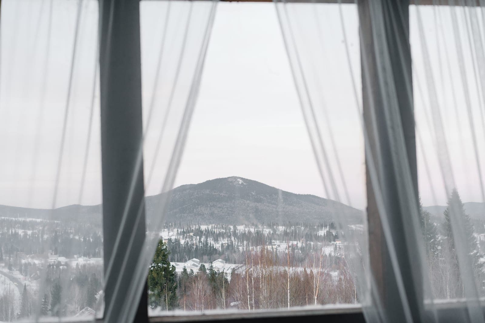 Heavy thermal curtains drawn across a window in a cold room