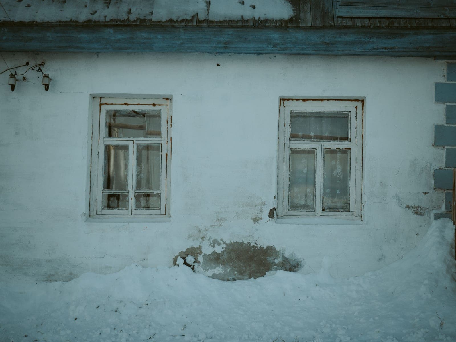 An old wooden window frame with a visible gap letting in cold air