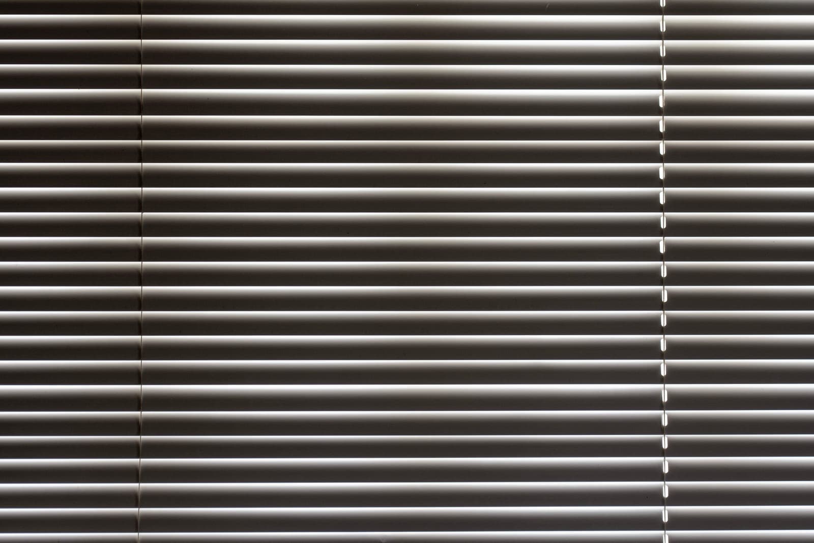 Venetian blinds closed across a window in a quiet room