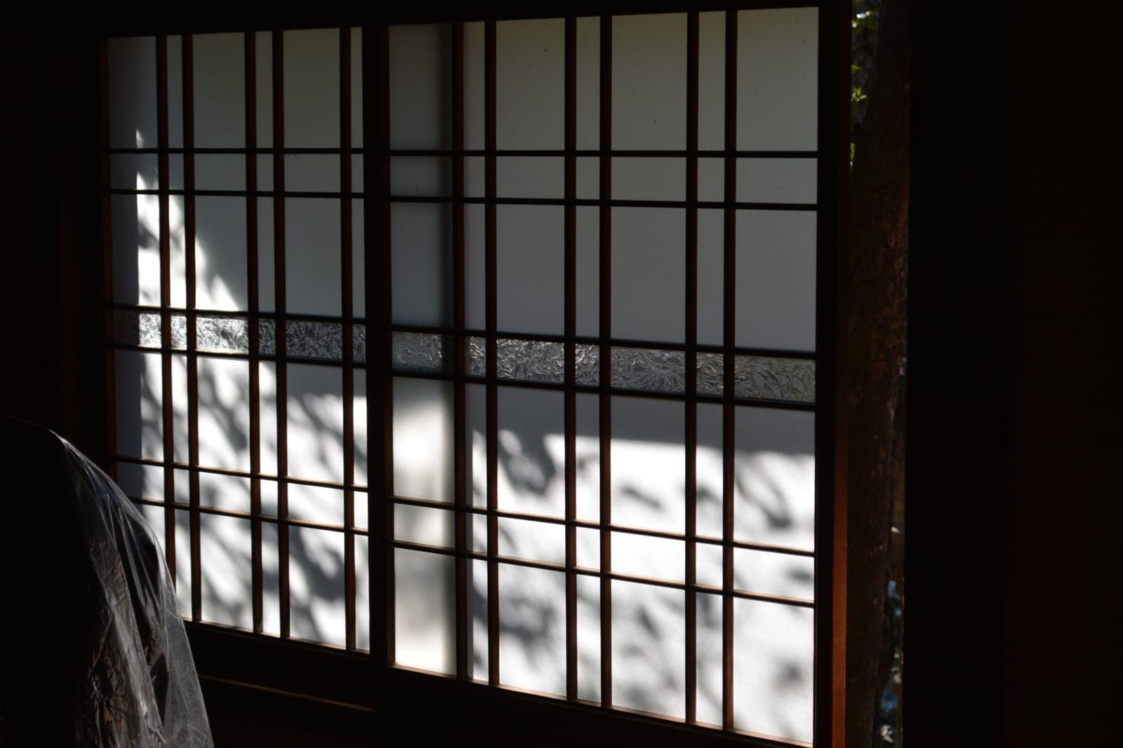 A window shade lowered from the top with daylight above it
