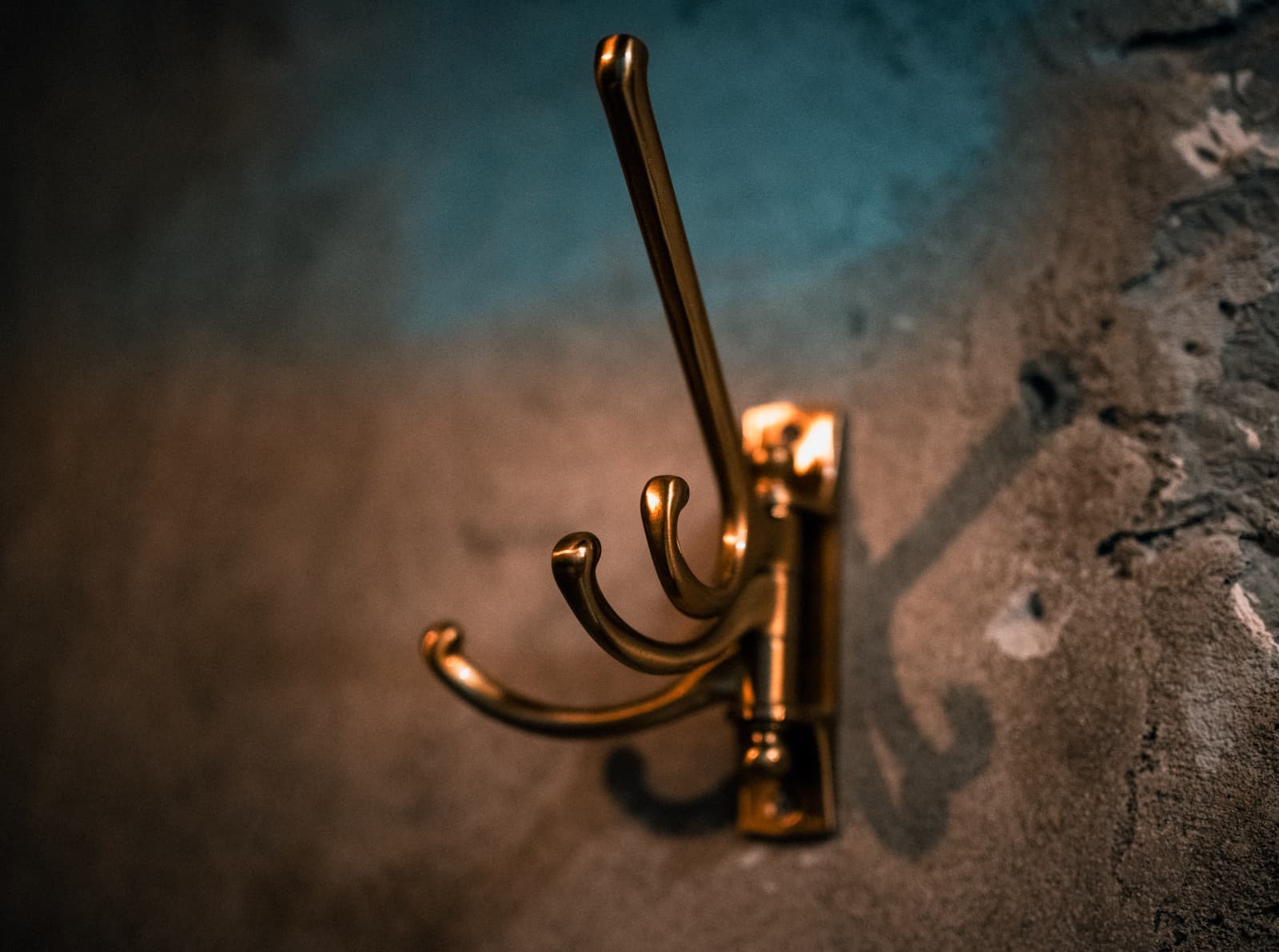 An adhesive hook mounted on a plain painted wall
