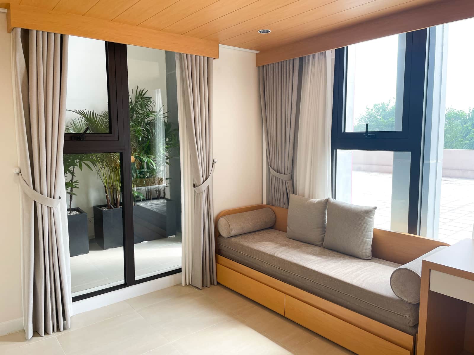 A bay window with a seat and curtains at each section
