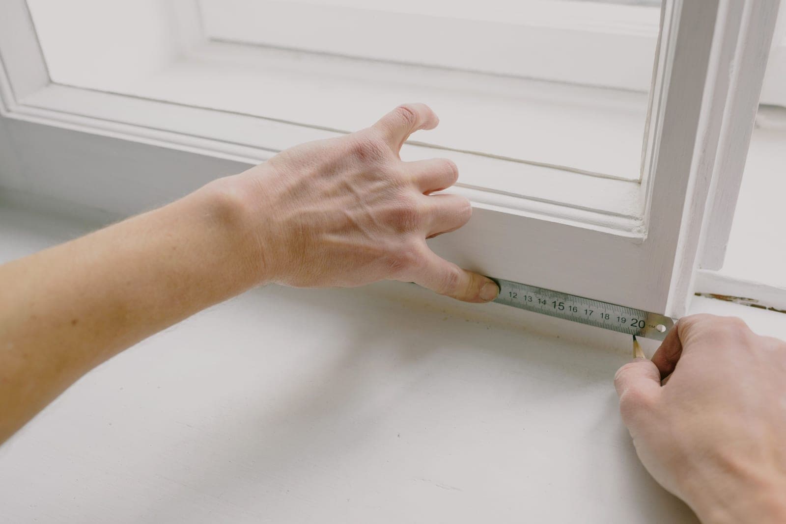 A measuring tape held against a window frame