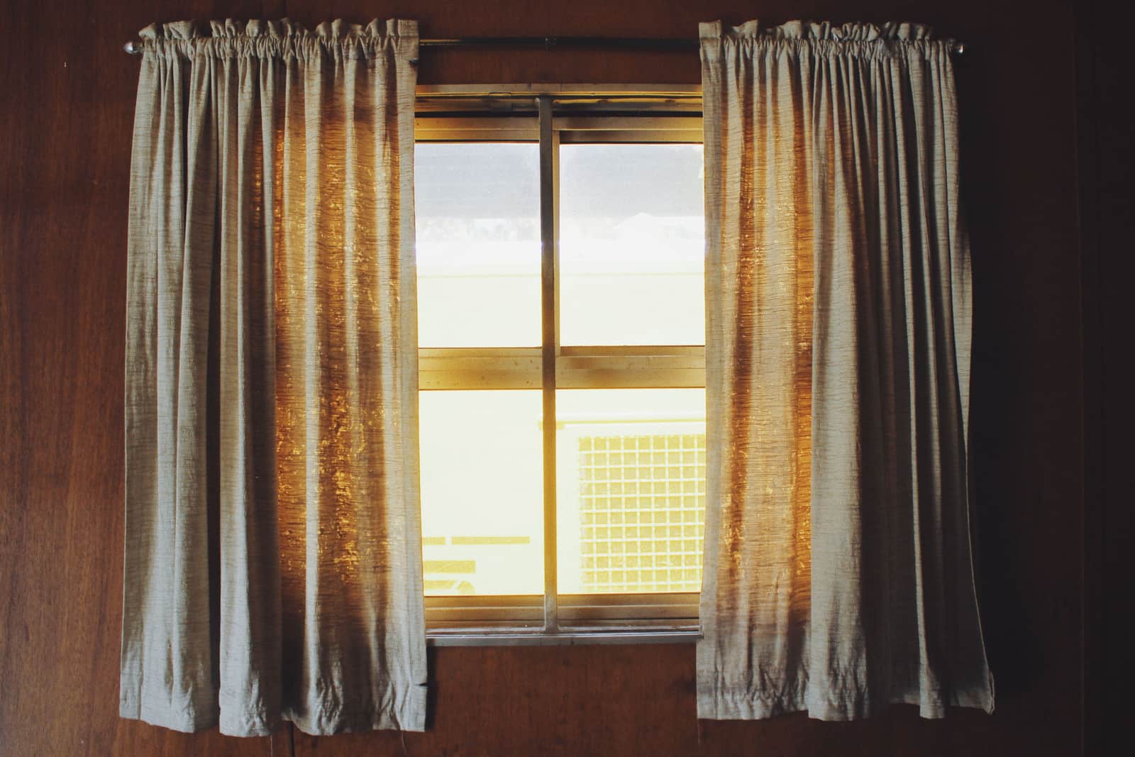 A curtain rod bracket fixed to the wall beside a window