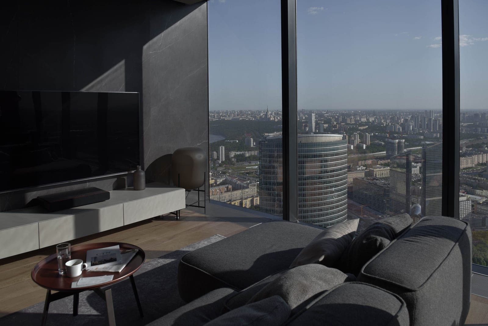 A living room with a large window and daylight falling across the sofa