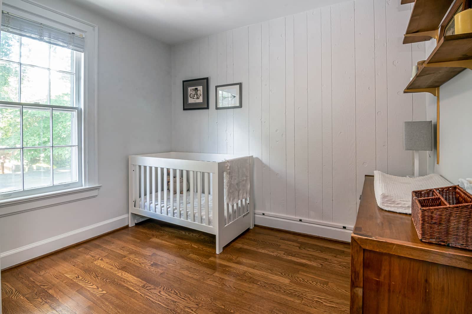 A nursery with a crib beside a window in soft light