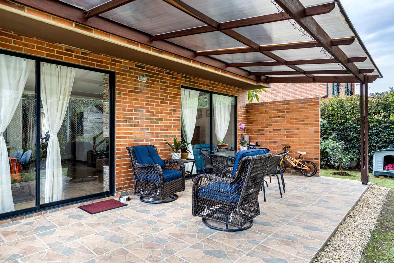 A sliding glass patio door with curtains drawn to one side